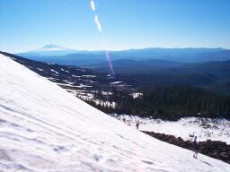 Traversing a snowfield, with Mt. Adams looking on.